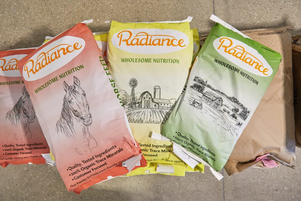 Radiance brand animal feed bags with wholesome nutrition labels, displayed on a concrete floor